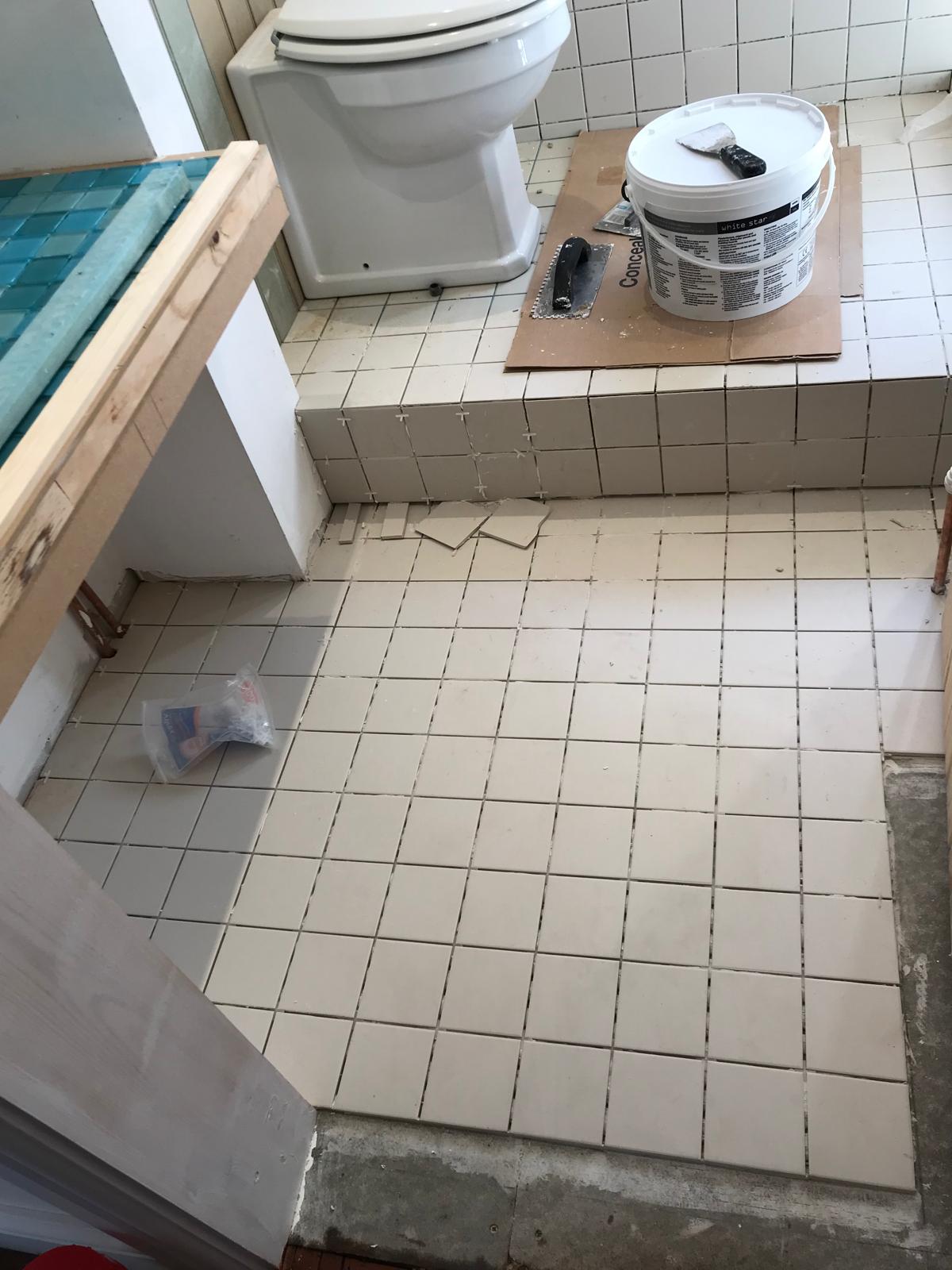 White tiles being installed on floor on local bathroom project