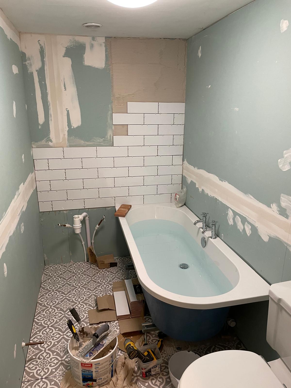 White wall tiles being installed on a bathroom project
