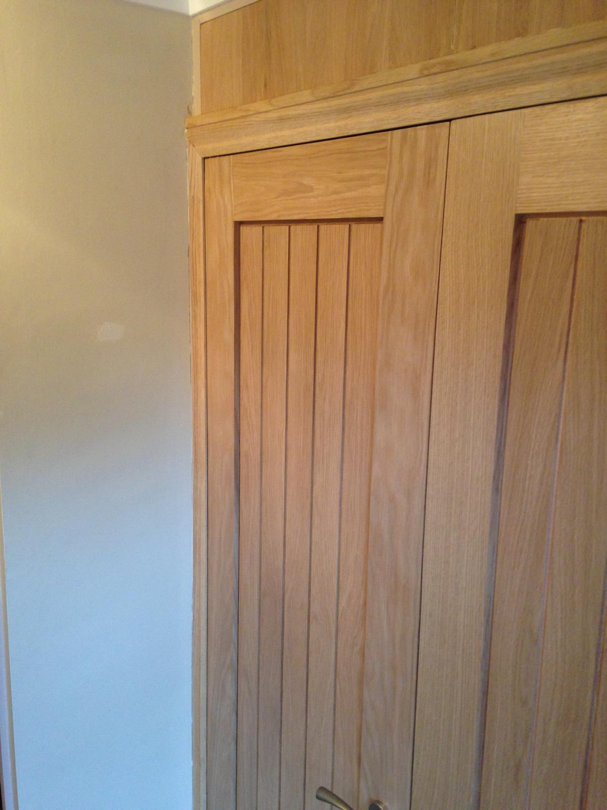 Wood effect top panel installed above doors for a local project
