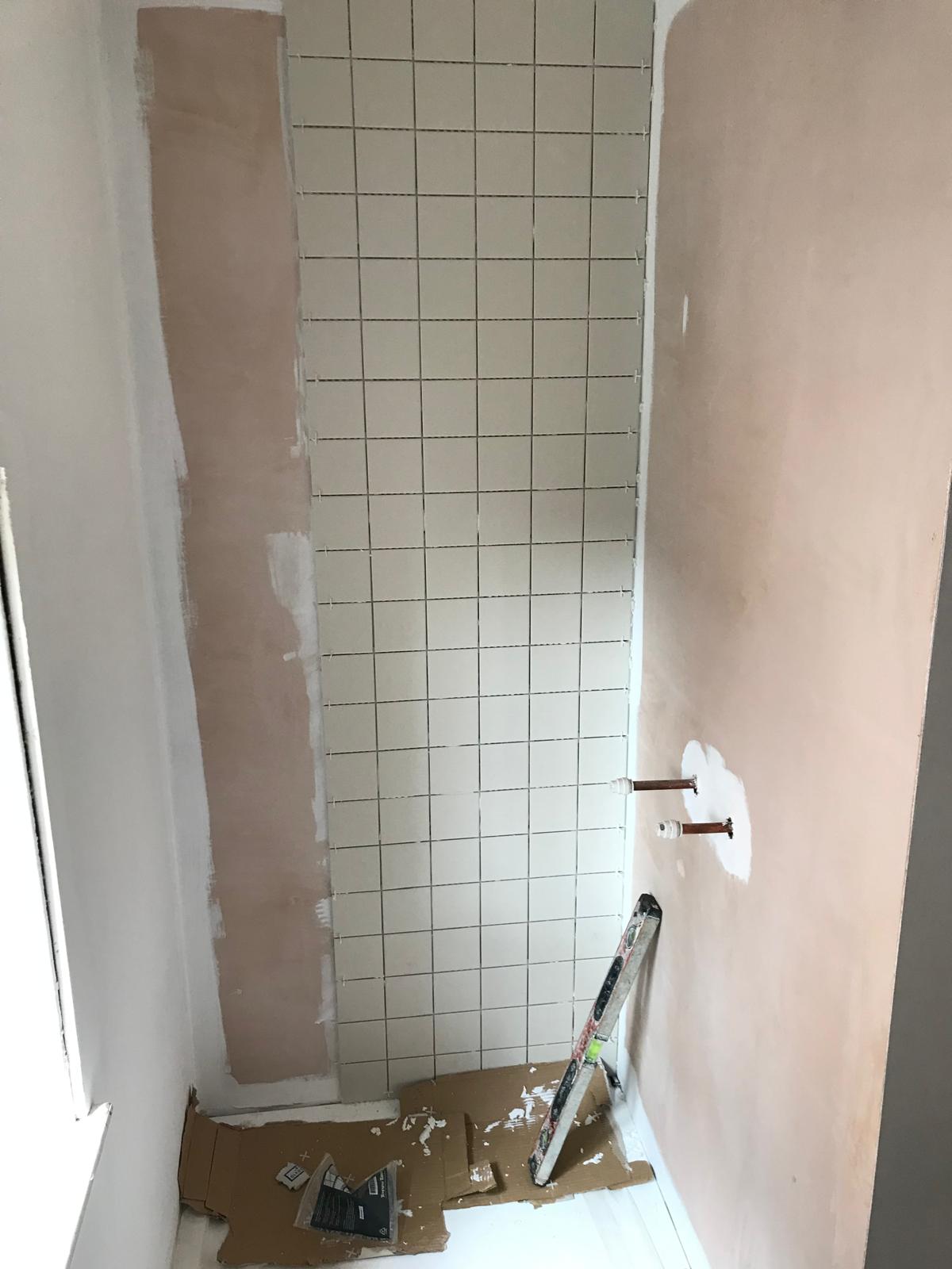 white wall tile installation in a shower area 